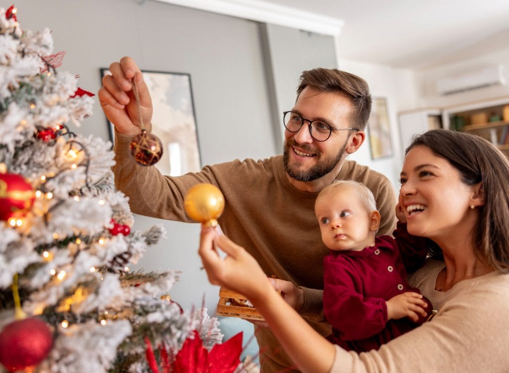 young couple decorating Christmas tree