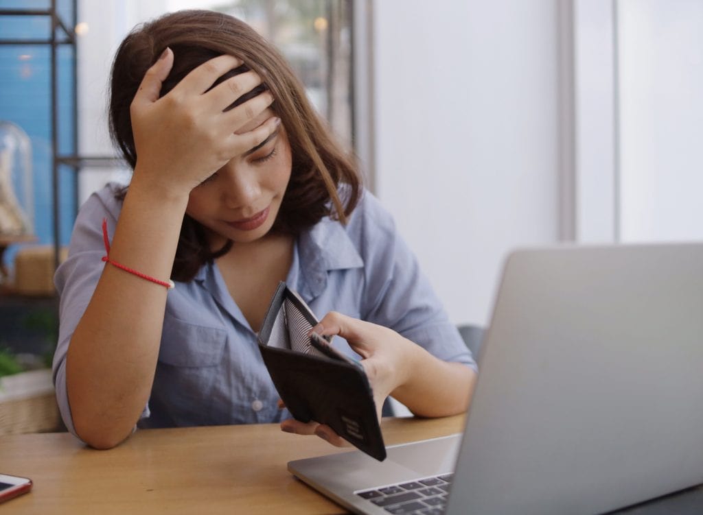 a woman upset that she has no money in her wallet