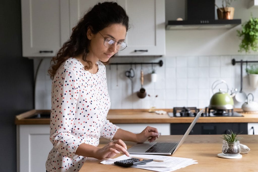 woman thinking about a loan application in kitchen