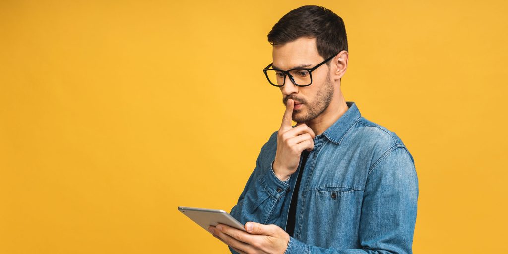 Kiwi guy looking at a table titled “Can I get a bad credit loan in New Zealand?” while exploring options with East Bay Finance.
