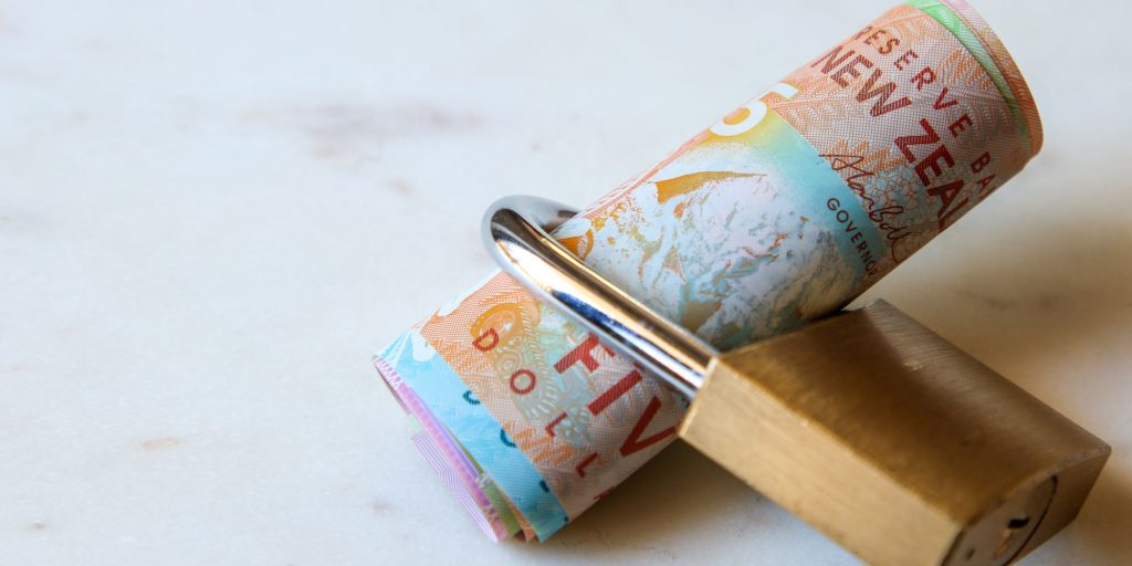 New Zealand currency secured with a lock — visual representation of how secured loans for bad credit work with East Bay Finance