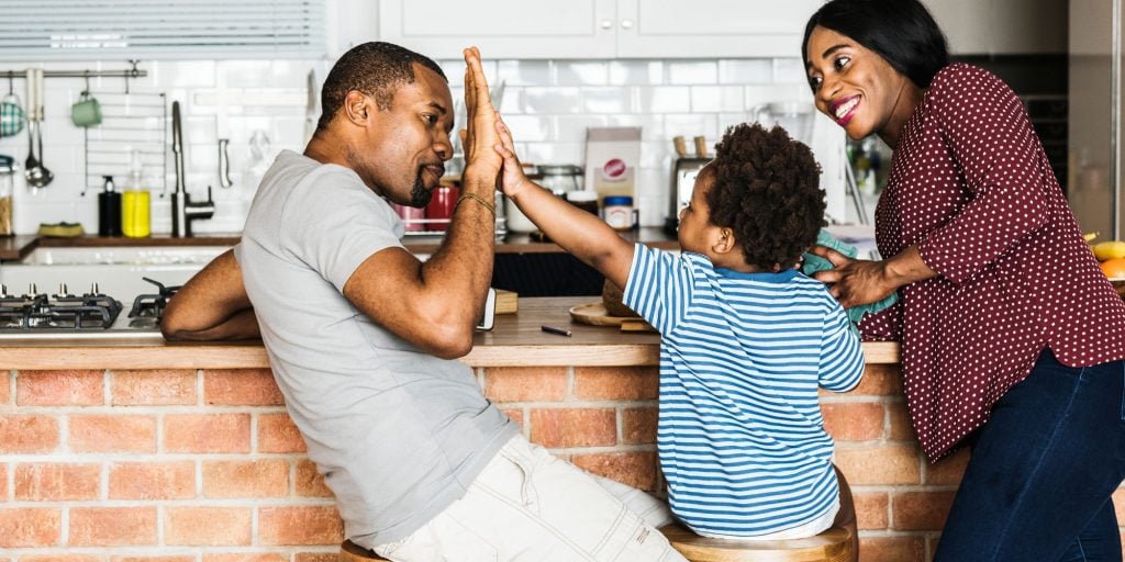 Happy couple giving a high five to their child — celebrating secured loan approval for bad credit through East Bay Finance.